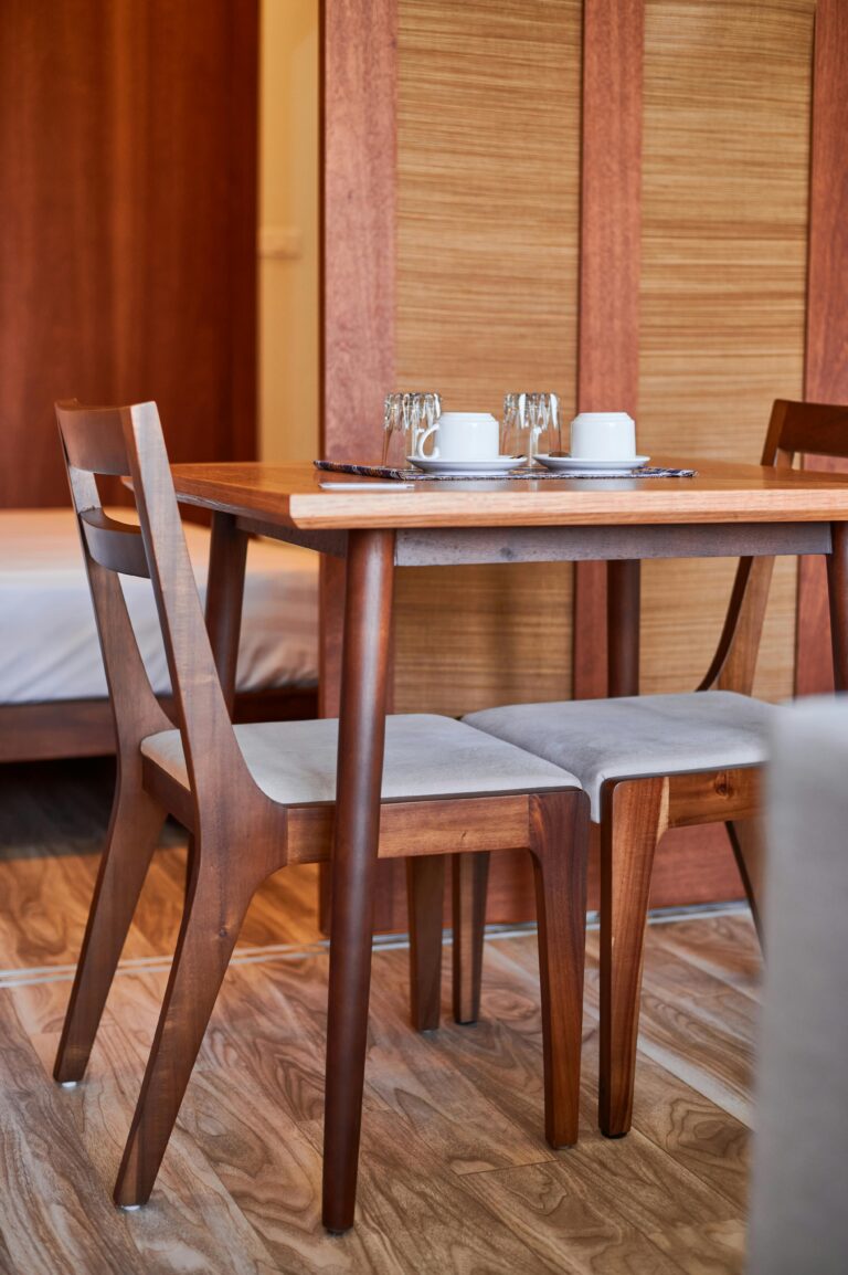 A cozy indoor dining setting featuring wooden table and chairs with mugs and glasses.